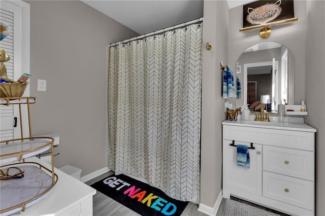 bathroom featuring walk in shower, vanity, and hardwood / wood-style floors