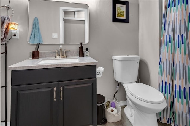 bathroom featuring hardwood / wood-style flooring, vanity, toilet, and curtained shower