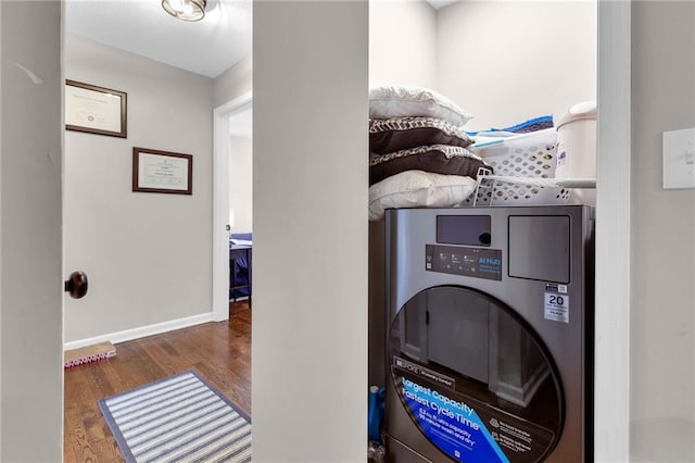 clothes washing area with dark wood-type flooring and washer / dryer