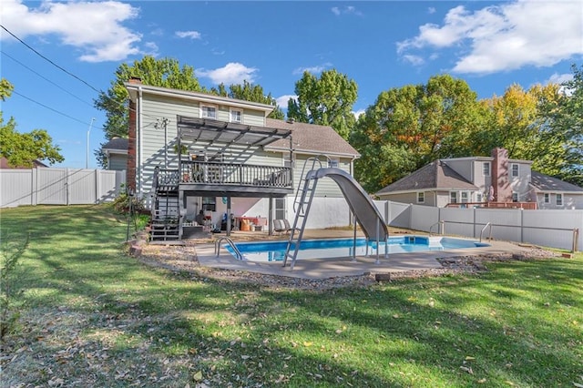 view of swimming pool with a patio, a yard, and a water slide