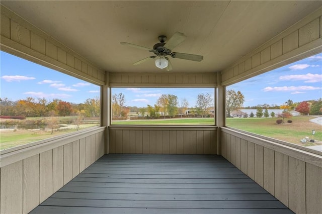 unfurnished sunroom with ceiling fan and plenty of natural light