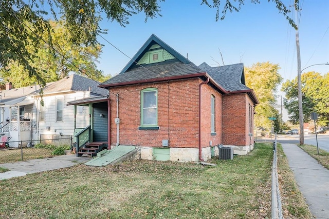 view of front of house featuring a front lawn and cooling unit