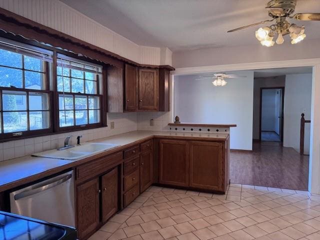 kitchen featuring dishwasher, backsplash, sink, ceiling fan, and kitchen peninsula