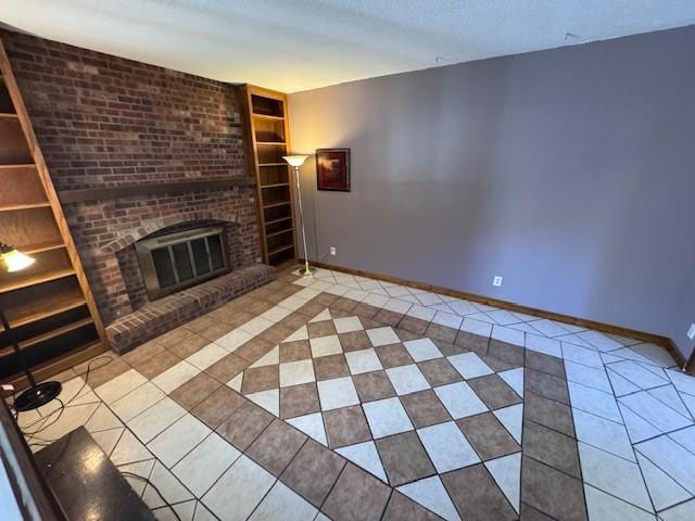 unfurnished living room with built in features, light tile patterned floors, a textured ceiling, and a brick fireplace