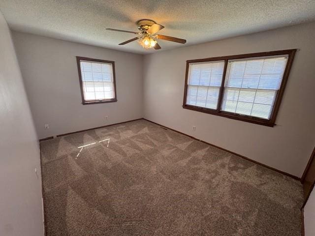 carpeted spare room with ceiling fan and a textured ceiling