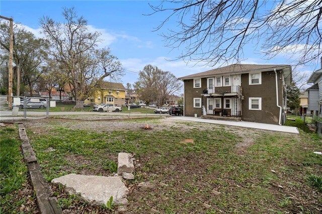 5121 Thompson Ave, Kansas City, MO 64124 - rear view of house featuring fence, a patio, and stucco siding