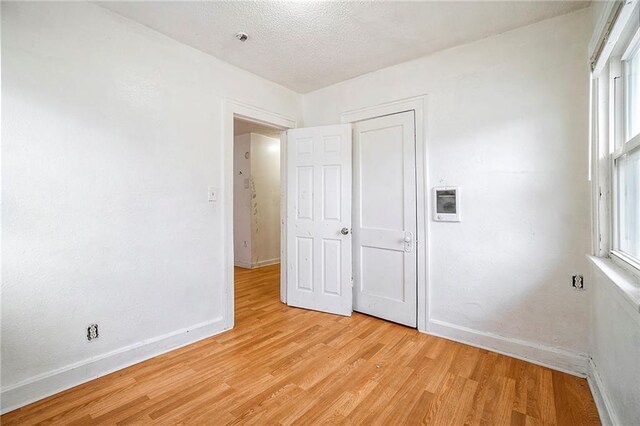 5121 Thompson Ave, Kansas City, MO 64124 - unfurnished bedroom with baseboards and light wood-style floors