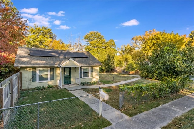 bungalow-style house featuring a front yard and solar panels