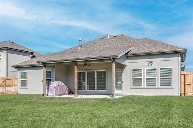 back of house featuring a lawn and ceiling fan