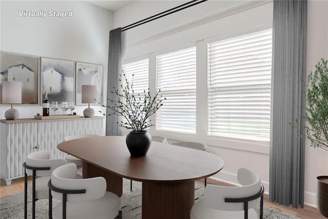 dining area with a wealth of natural light and light hardwood / wood-style flooring