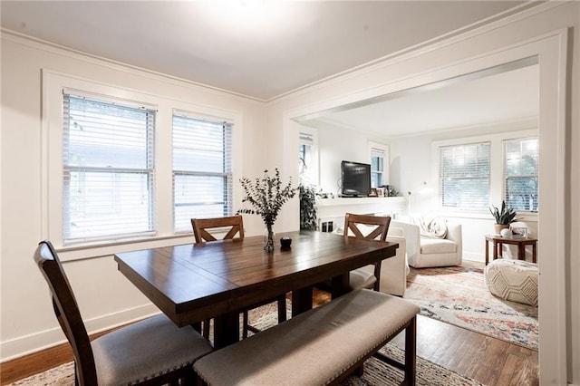 dining area with crown molding and hardwood / wood-style flooring