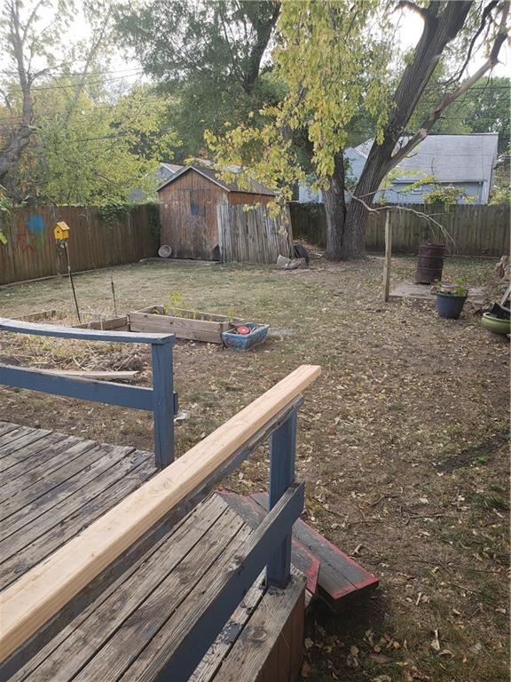 view of yard with a deck and a storage shed