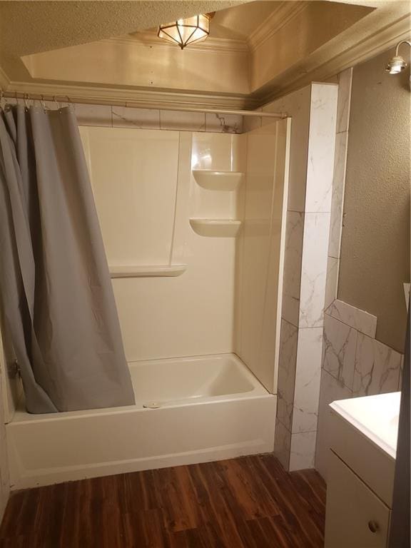 bathroom featuring hardwood / wood-style flooring, vanity, ornamental molding, and shower / bath combo