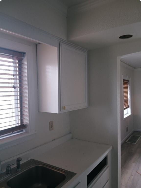 kitchen featuring white cabinets, light hardwood / wood-style floors, and sink