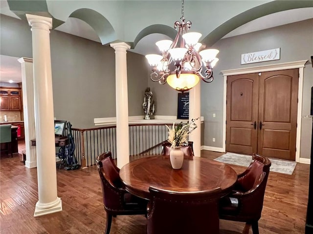 dining space featuring decorative columns and dark hardwood / wood-style flooring