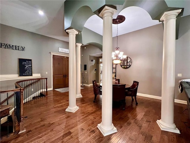 dining space with decorative columns and hardwood / wood-style floors