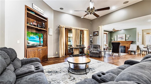 living room with ornate columns, wood-type flooring, and ceiling fan