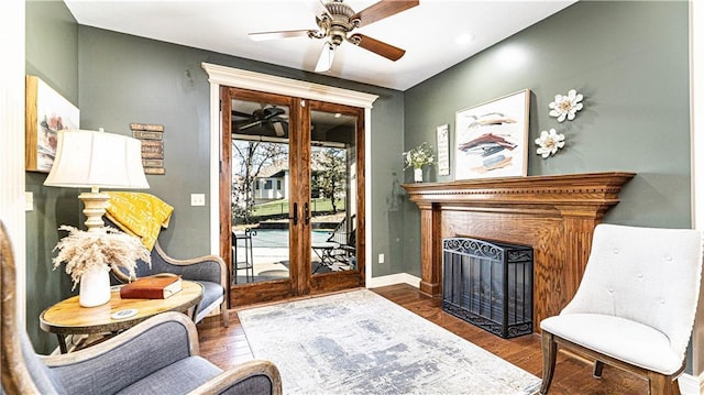 living area featuring dark hardwood / wood-style floors, ceiling fan, and french doors