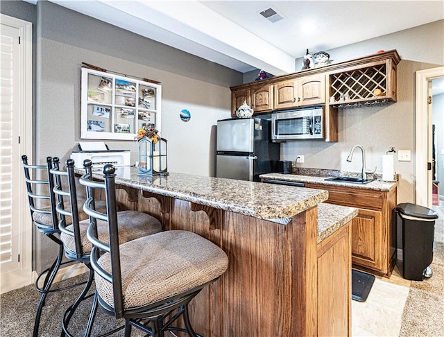 kitchen with sink, stainless steel appliances, and a kitchen bar