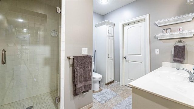 bathroom with vanity, a shower with shower door, and toilet