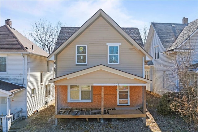 rear view of property featuring a shingled roof