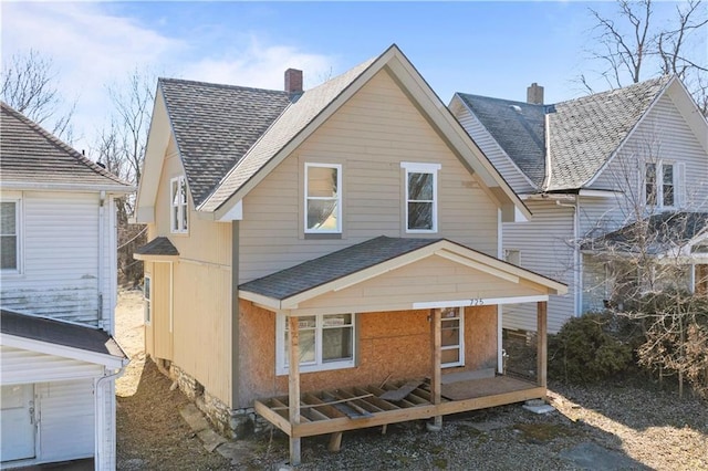 view of front of home with a shingled roof and a chimney