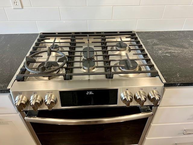 details with high end stainless steel range and white cabinets