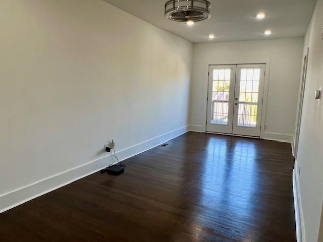 unfurnished room featuring french doors and dark wood-type flooring