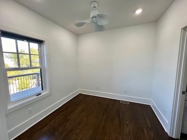 unfurnished room featuring ceiling fan and dark wood-type flooring