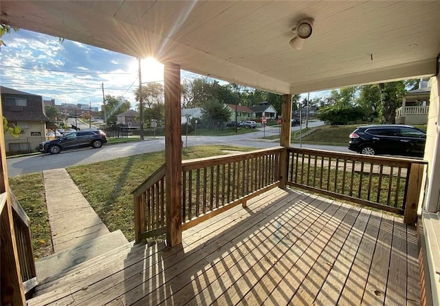 wooden terrace featuring a lawn