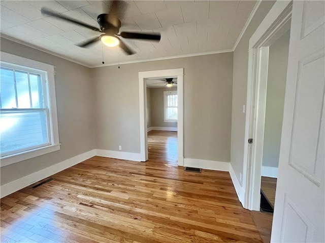 unfurnished room with ceiling fan, ornamental molding, and light wood-type flooring