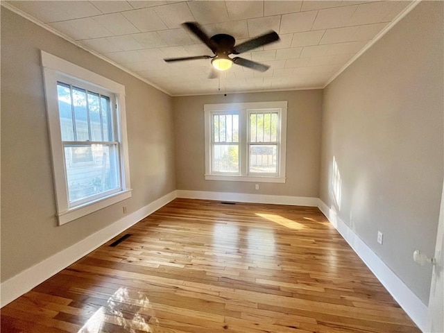 unfurnished room with crown molding, light hardwood / wood-style flooring, a healthy amount of sunlight, and ceiling fan