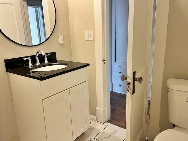 bathroom with vanity, toilet, and hardwood / wood-style flooring