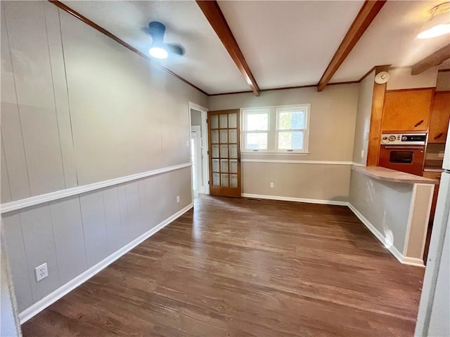 unfurnished dining area featuring beamed ceiling and dark hardwood / wood-style flooring