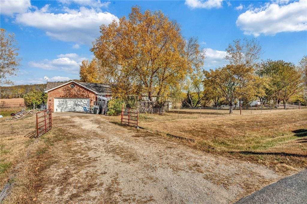 view of yard with a rural view and a garage