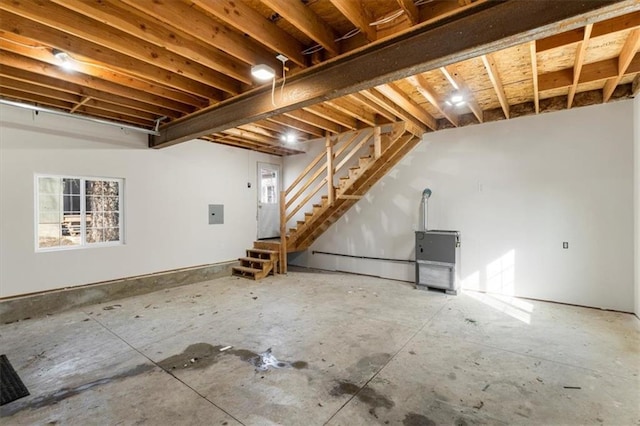 below grade area with electric panel, stairway, and plenty of natural light