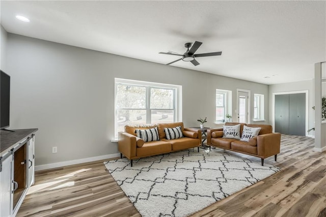 living room featuring light wood-type flooring and ceiling fan