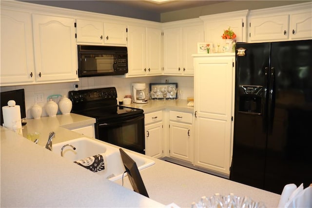 kitchen with black appliances, white cabinets, and tasteful backsplash