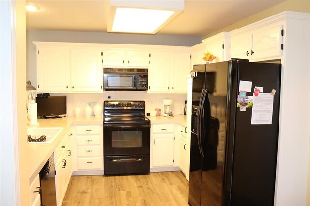 5850 Park Cir, Shawnee, KS 66216 - kitchen featuring black appliances, light countertops, light wood-style flooring, tasteful backsplash, and white cabinets