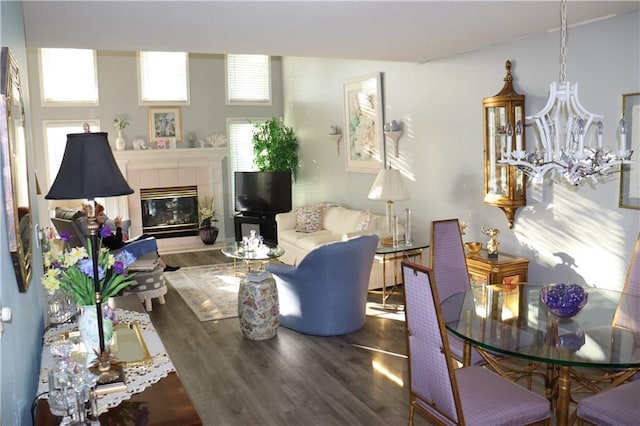 living room featuring hardwood / wood-style floors, a tiled fireplace, and a chandelier