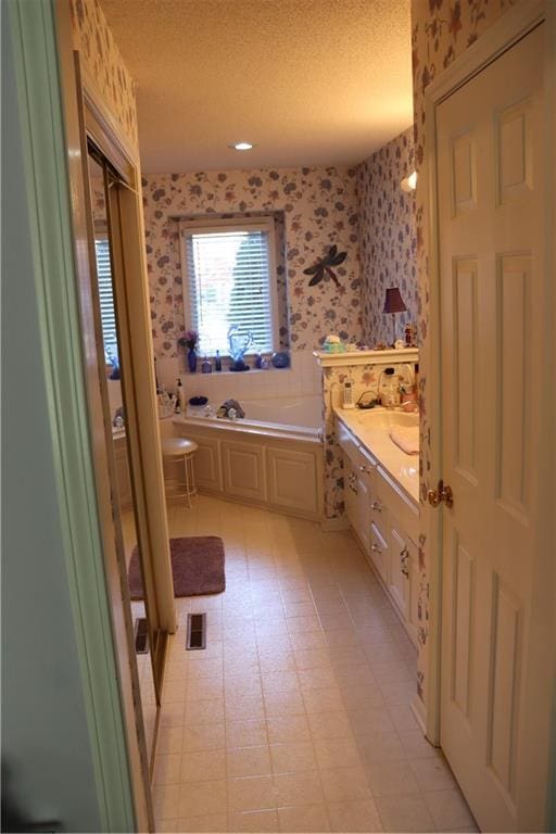5850 Park Cir, Shawnee, KS 66216 - full bathroom with wallpapered walls, a garden tub, a textured ceiling, vanity, and tile patterned floors