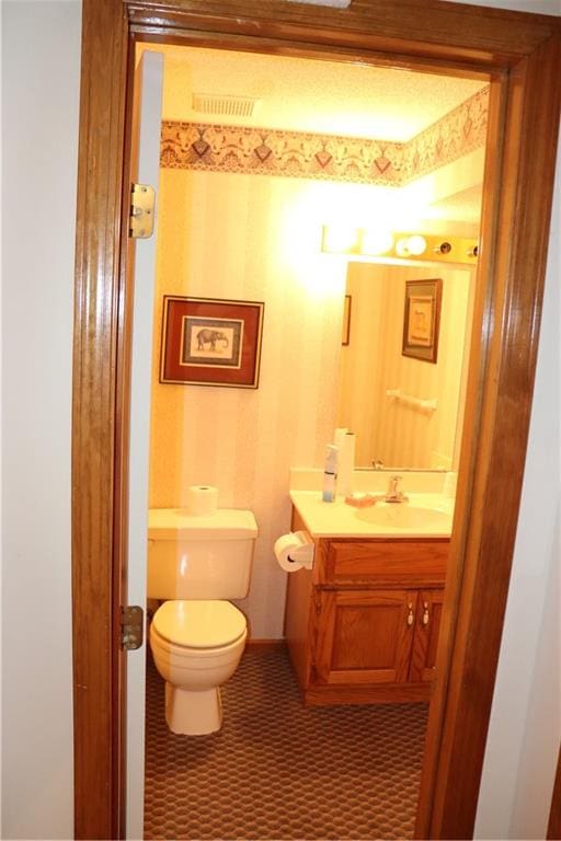 bathroom featuring vanity, toilet, and tile patterned floors