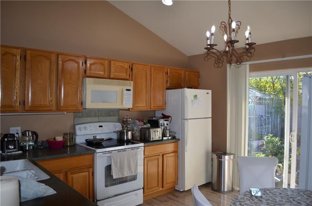 kitchen featuring white appliances, hanging light fixtures, light hardwood / wood-style floors, lofted ceiling, and an inviting chandelier