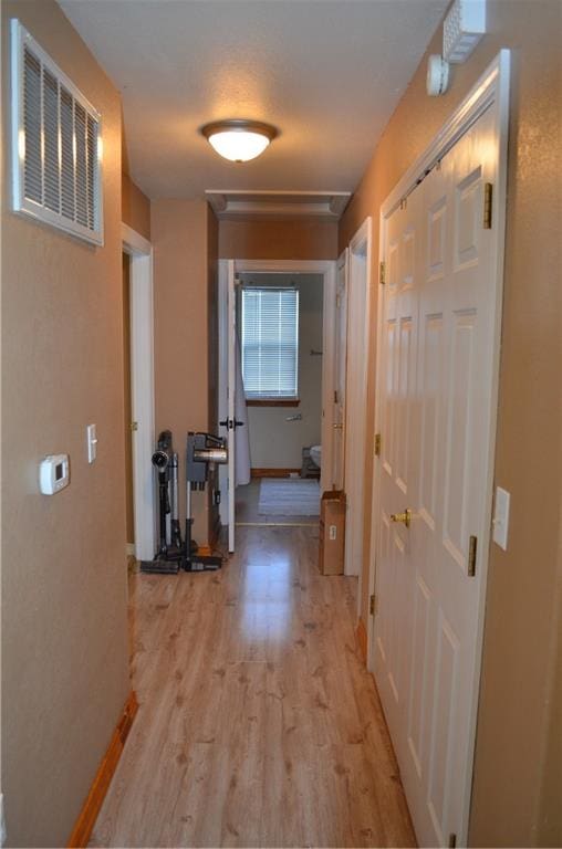 corridor with light hardwood / wood-style floors