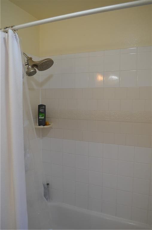 bathroom with shower / bath combo with shower curtain