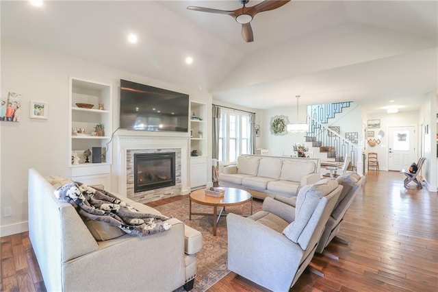 living room featuring vaulted ceiling, ceiling fan, a fireplace, and dark hardwood / wood-style flooring