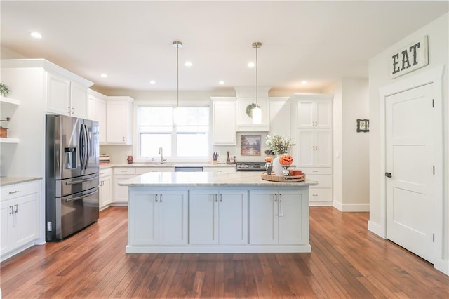 kitchen with dark hardwood / wood-style flooring, white cabinetry, stainless steel appliances, and pendant lighting