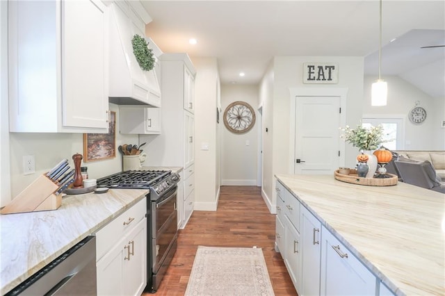 kitchen featuring black range with gas stovetop, hanging light fixtures, stainless steel dishwasher, premium range hood, and white cabinetry