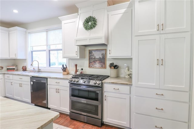 kitchen with sink, white cabinets, light hardwood / wood-style flooring, and stainless steel appliances