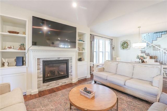 living room featuring vaulted ceiling, dark hardwood / wood-style floors, and built in features